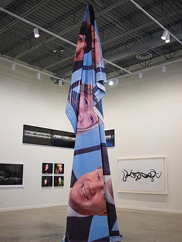 A photo of a tall pointed sculptural work in the center of a contemporary art gallery