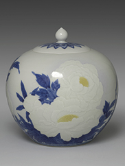 An image of a lidded ceramic jar with white and blue floral designs 