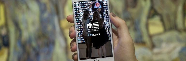 [image: a hand holding in iPhone, showing the opening screen of the ArtLens App]