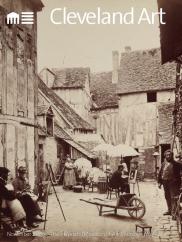 magazine cover with black and white photo of old  french village, courtyard with painters and a wheelbarrow