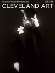 black & white photo of a person in an all black suit, wearing a zebra mask and a white flower in the lapel,  tipping a top hat  with an all black background  by Carrie Mae Weems on the magazine cover 